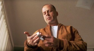Bruce Willis looks down at a wrist watch in the movie Pulp Fiction.